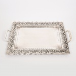 METAL PRATEADO, uma (1) bandeja retangular, borda martelada e relevada em elementos vegetalistas, alças marteladas, medindo 46 x 37 cm mais as alças, sem marca de manufatura aparente, vide foto.