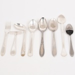 FAQUEIRO, oito (8) talheres variados, confeccionados em metal prateado e aço inox: 1 garfo da marca EBERLE; 1 talher para criança, marca WOLFF, ornado com frisos e guirlandas de tulipas, marca possessória gravada AC; 1 colher para criança, marca BELLINI, ornada com frisos e volutas; 1 colher longa e sem marca; 3 colheres de sobremesa distintas, marcas RADIO, EBERLE e WOLFF, ornamentações variadas; 1 colher para molho de pimenta, marca EBERLE, medindo a maior peça 18,5 cm comprimento, vide foto.