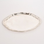 METAL PRATEADO, uma (1) travessa oval com borda plissada e relevada em volutas, sem marca de manufatura aparente, medindo 28,5 x 20,5 cm, vide foto.