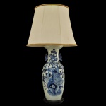 Belíssimo vaso em porcelana chinesa decorado em azul underglaze sobre branco. Bojo abaulado, ornado por composição com pavão sobre rochedo, crisântemos e outras flores. Gargalo em corneta, ladeado por pegas estilizadas e rematado por borda revirada. Montagem para luminária de mesa com cúpula lobulada em tecido bege. Peça com inspiração na dinastia Qing, era Kangxi. 97 x 24 (MT). 59 x 24 cm (base). 40 x 54 cm (cúpula)