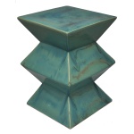 Banqueta contemporânea em cerâmica revestida por esmaltes mesclados de cor azul turquesa. Apresenta montagem com três segmentos piramidais superpostos. 46 x 32 x 32 cm. Acervo Particular MAVP.