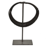 Colar tribal em ferro, possivelmente africano, construído com argolas ovaladas montadas sobre gargantilha circular espiralada. Suporte reto apoiado em base retangular. 22 x 24 cm / 36 x 17 x 8 cm (MT). Acervo Particular MAVP.