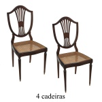 Conjunto de 4 cadeiras em madeira nobre, estilo inglês Hepplewhite. Encostos no formato de escudos vazados com hastes arqueadas reunidas ao centro por adornos lisos. Assentos forrados em palhinha da Índia, apoiados em saias com discretos recurvos. Pernas retilíneas e afinadas. 100 x 44 x 43 cm. Acervo Particular Maria Anna do Valle Pereira, SP.
