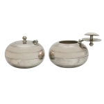 CHRISTOFLE, France. Modelo Boule - Par de cinzeiros de mesa para charutos em metal espessurado a prata com tampa articulada com um pequeno puxador no topo. Design esférico com linhas horizontais. 7 x 8 cm. É considerado um item de luxo e decoração da marca francesa Christofle. Acervo Particular Maria Anna do Valle Pereira, SP.