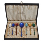 Conjunto de seis colheres para café em prata vermeil dinamarquesa, ornamentadas por esmaltes coloridos. Contrastes da prata Sterling e do teor de 925 mls. Acompanha estojo original com interior forrado em seda, trazendo selo da casa IMHOF S.A. Orfèvrerie Genève. 13 cm (colher) / 16 x 16 cm (estojo) / 68 gramas. Acervo Particular MAVP.