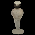 Frasco para perfume em vidro satinado fosco com relevos decorativos no estilo Art Déco. Apresenta figuras ou ninfas em relevo ao longo do corpo. Base oitavada rematado por uma tampa trabalhada e achatada. 14 x 16 cm.