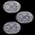 Conjunto de três travessa em porcelana chinesa Macau apresenta um design clássico em azul e branco.  com decorações de paisagens orientais, árvores e pagodes. Marca da manufatura no verso. 20 x 15 cm.