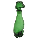 Decantador de vidro verde em formato de cachorro, Peça feita de vidro moldado, com o corpo do cachorro servindo como a garrafa e a cabeça funcionando como a rolha. 22 x 7 x 6 cm.