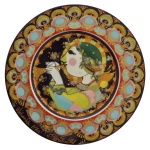 ROSENTHAL GERMANY (Studio-Linie) - "Engel mit Trompete" (Anjo com Trompete) - Prato decorativo colecionável de Natal de 1976 (Weihnachtsteller 1976) em porcelana policromada com decorações e ornamentos detalhados em ouro. Faz parte de uma célebre série anual de pratos natalinos desenhados por Bjrn Wiinblad, para a marca ao longo das décadas de 1970 e 1980. 29 cm. 30 x 30 cm (estojo).