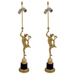 Luminária de mesa apresentando uma do deus Mercúrio em pé sobre uma base de pedra preta. A figura segura o tradicional caduceu em uma das mãos e usa o capacete alado e foi adaptada como base estrutural para iluminação, estendendo-se verticalmente até um bocal duplo para lâmpadas. Apoia-se sobre um pedestal cilíndrico escuro com anéis e molduras em bronze polido na extremidade inferior. 87 x 21 x 4 cm.