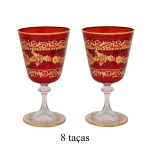 Conjunto de 8 taças para água em cristal veneziano na cor vermelho rubi com ornamentos em ouro. Apresenta arabescos dourados detalhados aplicados sobre o corpo vermelho, criando um contraste sofisticado. 18 x 7 cm.