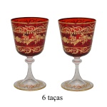 Conjunto de 6 taças para vinho em cristal veneziano na cor vermelho rubi com ornamentos em ouro. Apresenta arabescos dourados detalhados aplicados sobre o corpo vermelho, criando um contraste sofisticado. 15 x 8 cm.