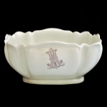 HAVILAND & CO, Limoges  Bowl ovalado, com laterais moldadas em gomos, em porcelana francesa branca. Recipiente abaulado, encimado por borda recortada. Apresenta à frente monograma entrelaçado . Marcas da manufatura sob a base.