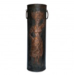 Bengaleiro ou porta-guarda-chuva em cobre. Apresenta um design cilíndrico com alças laterais e relevos decorativos que retratam uma figura humana em estilo rústico. 60 x 20 cm.