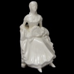 COALPORT. Made in England - Barbara. Estatueta moldada em porcelana inglesa e policromada, representando dama com vestido branco e leque. Sob a base, marcas da manufatura com numeração Bone China. 13 x 8 cm.