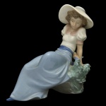 LLADRÓ BYTE NAO 1042 Liste Ning to the Birds Song. Estatueta espanhola em porcelana brilhante e policromada representando menina escutando o canto do pássaro. Sob a base marca da manufatura de 1987. 15 x 14 cm.