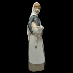 LLADRÓ 4584, Designer Alfredo Ruiz (1969-1993) - Girl With Lamb - Estatueta espanhola em porcelana brilhante e policromada representando menina com ovelha. Sob a base marca da manufatura. 27 x 8 cm.