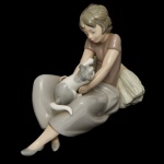 LLADRÓ BY NAO 1578. Titulada Young Girl with Kittin - Estatueta espanhola em porcelana brilhante e policromada representando jovem menina com gatinho, de 1981. Sob a base marca da manufatura. 15 x 20 cm.