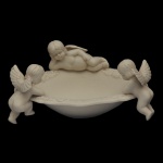 Saboneteira em cerâmica na cor creme com delicadas figuras de querubins em relevo nas bordas. 6 x 15 x 12 cm.