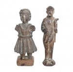 Séc. XIX - Conjunto de duas antigas esculturas sacras esculpidas em madeira entalhada e policromada. A) Figura infantil de pé , possivelmente Menino Jesus com túnica curta e cinco apoiada sobre uma base de madeira quadrada. Representação figurativa de uma criança com traços rústicos e base de apoio individual. B) Acompanha santo, possivelmente São José, com cajado na mão. tom escuro, representando uma figura humana ereta com trajes tradicionais e feições definidas. 8 x 3 cm / 8 x 2 cm. Desgastes naturais, rachaduras na madeira e perdas na camada pictórica (policromia) são normais em peças de época,