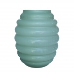 Vaso contemporâneo e decorativo em vidro de cor verde menta com acabamento opaco. Silhueta marcante com gomos horizontais repetidos que criam um efeito visual de ondas e movimento.