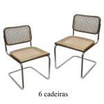 Conjunto de 6 cadeiras com estruturas tubulares em metal cromado. Encostos e assentos retangulares, emoldurados por frisos lisos em madeira, forrados com palhinha da Índia. Pernas retas apoiadas sobre bases em U. 80 x 46 x 50 cm.