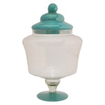 Bomboniere em vidro translucido e liso. Apresenta um design elegante com pé e tampa na cor verde. Ideal para armazenar doces, balas ou como peça decorativa. 35 x 25 cm.
