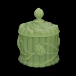 Pote com tampa em vidro opalinado na cor verde jade. Decoração em relevos florais e caneluras. Pega da tampa na forma de pinha. 14 x 10 cm.