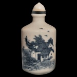 SÉC. XIX - Snuff Bottle de formato cilíndrico em porcelana chinesa decorada em azul. Apresenta típica técnica de pesca usando cormorões. Tampa com colar preto e colher. Assinada sob a base. Séc. XIX.