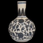 Pequeno vaso em porcelana chinesa, decorado em azul. Bojo globular ornado com folhagens e flores, encimado por gargalo reto com friso de folhas. Assinado sob a base.