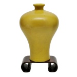 SÉC. XVIII - Raro vaso em porcelana chinesa, de formato conhecido como Meiping, ornado por esmalte monocromático amarelo e liso. Acompanha base em madeira.
