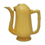 SÉC. XVIII - Original bule do tipo Cadogan, com sistema de enchimento pela base, em porcelana chinesa no formato de abóbora, ornado por esmalte monocromático amarelo. Bojo alongado, moldado com suaves gomos. Alça lateral e bico longo e recurvo, imitando galhos e rematados ao corpo por folhagens. Base circular.