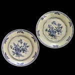 CHINA. Reinado Qianlong (1736-1795) - Par de pratos em porcelana chinesa da Companhia das Índias, decorados em azul. Bordas realçadas por frisos geométricos, centralizando arranjos florais emoldurados por filetes ondulados. 24 cm.