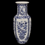 Vaso em louça azul e branca, inspirado no clássica faiança holandesa  tradicional, como as peças de Delft. O modelo apresenta um formato alongado com gargalo cintilante e corpo bojudo, ricamente decorado com padrões florais detalhados em azul cobalto sobre fundo off-white. No verso marca da manufatura. 30 x 12 cm.