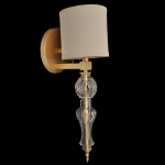 Aplique de parede contemporânea em bronze dourado, com suporte circular. Braço reto sustentando haste tubular, recamada na parte inferior por manga em cristal moldado com adornos abaulados. Parte superior com pequena cúpula em tecido bege. 52 cm (MT). 16 x 16 cm (cúpula).