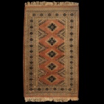 Tapete paquistanês de estilo tribal e nômade, medindo 156 x 94 cm. Caracterizado por seus medalhões geométricos centrais dispostos verticalmente. Confeccionada artesanalmente em lã, em tons terrosos predominantes de terracota, cercados por bordas ornamentadas. Sinais de uso e do tempo.