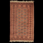 Tapete Persa Bukhara medindo 127 x 81 cm. Apresenta um padrão geométrico tradicional com motivos florais octogonais em tons de vermelho e azul. Sinais de uso e do tempo.