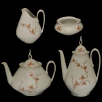 Conjunto para chá e café em porcelana nacional da manufatura Real. Superficie branca com decoração floral delicada e filete dourado nas bordas. Constando de 4 peças, sendo: 1 bule p/ café (25 x 17 cm), 1 bule p/ chá (20 x 27 cm), 1 cremeira (14 x 12 cm) e 1 açucareiro sem tampa (5 x 13 cm).