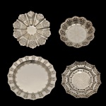 Lote constando de 4 fruteiras em metal prateado de modelos diferentes, sendo: 1 fruteira com pé (6 x 7 cm), 1 bandeja rasa (33 cm), 1 fruteira com pé (27 cm) e base (5 x 25 cm). Manufaturas Prata Régia 90 e Ata Span 90.