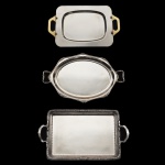 Lote constando de 3 bandejas em metal prateado de manufatura nacional Wolff, sendo: 1 de formato retangular com alças douradas (44 x 26 cm), 1 de formato oval (52 x 33 cm), e 1 de formato retangular (56 x 33 cm). Sinais de uso e do tempo.