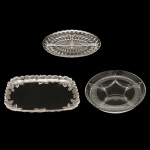 Lote constando de 3 peças em vidro translucido, sendo: 1 petisqueira de formato oval (3 x 30 cm), 1 saladeira retangular com bordas decorada com flores em relevo (4 x 35 x 25 cm) e 1 petisqueira 2 x 29 x 21 cm.