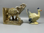 DIVERSOS - Suporte para livros em resina, representando um elefante e um pavão em cerâmica. Marcas do tempo e de uso.