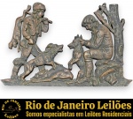 PLACA EM ALTO-RELEVO, DITO GRUPO ESCULTÓRIO, EXECUTADA EM METAL FUNDIDO COM ACABAMENTO EM PÁTINA, POSSIVELMENTE BRONZE, EXIBINDO RICA CENA DETALHADA DE CAÇADORES EM ESTILO EUROPEU TRADICIONAL, RETRATANDO DOIS CAÇADORES TRAJADOS COM VESTIMENTAS TÍPICAS, ACOMPANHADOS POR SEUS CÃES DE CAÇA EM MEIO A UMA JORNADA, REVELANDO UMA PRESA (VEADO) AO CHÃO, OUTRA EM TRANSPORTE E DETALHES DE ARVOREDO, MEDINDO 20 X 32 CM. APRESENTA MARCAS DO TEMPO, USO, SINAIS, DESGASTES E/OU PEQUENAS IMPERFEIÇÕES COMPATÍVEIS COM SUA IDADE E ESTADO DE CONSERVAÇÃO, CONFORME FOTOS EXTRAS. ESCLAREÇA TODAS AS DÚVIDAS ANTES DE EFETUAR SEU LANCE, QUE SERÁ CONSIDERADO IRREVOGÁVEL E IRRETRATÁVEL. CONSULTE PREVIAMENTE OS TERMOS E CONDIÇÕES DISPONÍVEIS NO SITE. CONTATO (21) 98264-3000.