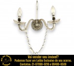 ARANDELA DE PAREDE PARA DOIS LUMES, TIPO VELA, ESTILO MARIA THEREZA. ESTRUTURA EM CRISTAL E VIDRO, APRESENTANDO COPAS ONDULADAS TIPO FLORES, BASE CIRCULAR TRABALHADA, SUPORTE CENTRAL VERTICAL, BRAÇOS CURVOS E TRANSLÚCIDOS, CORRENTES DE CONTAS, PRATOS (ARANDELA INFERIOR DE CADA BRAÇO) COM DESENHOS LAPIDADOS EM LOSANGOS, PINGENTES COM LAPIDAÇÃO EM AMÊNDOAS, PRISMAS E CONTAS FACETADAS, MEDINDO 30 X 40 CM. NÃO FORAM TESTADOS ESTADO DE FUNCIONAMENTO, INTEGRIDADE E/OU FUNCIONALIDADES DO ITEM. TRATA-SE DE PEÇA ELETROELETRÔNICA USADA, SENDO QUE EVENTUAIS TESTES E VERIFICAÇÕES REALIZADOS DURANTE A CATALOGAÇÃO REFLETEM APENAS AS CONDIÇÕES OBSERVADAS NAQUELE MOMENTO, DESTACANDO OXIDAÇÃO E FALTA DE CONTAS E PINGENTES, CONFORME FOTOS EXTRAS. TODAVIA, MANUSEIO, TRANSPORTE, ARMAZENAMENTO E NOVA INSTALAÇÃO, NÃO OFERECEMOS QUALQUER TIPO DE GARANTIA DE FUNCIONAMENTO APÓS A RETIRADA E/OU ENTREGA, DEVENDO O ARREMATANTE CONSIDERAR TAIS CONDIÇÕES PREVIAMENTE À ARREMATAÇÃO. ESCLAREÇA TODAS AS DÚVIDAS ANTES DE EFETUAR SEU LANCE, QUE SERÁ CONSIDERADO IRREVOGÁVEL E IRRETRATÁVEL. CONSULTE PREVIAMENTE OS TERMOS E CONDIÇÕES DISPONÍVEIS NO SITE. CONTATO (21) 98264-3000. ESTE LOTE COMBINA COM OS LOTES Nº 7 E 93.