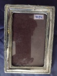 Porta retrato europeu, estilo vitoriano em prata cinzelada, fundo em madeira, contraste ilegível, com marcas de uso. Medidas: 17 x 12cm. Peso bruto sem vidro: 140g; Peso da prata: 45g.