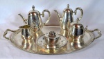 CHRSITOFLE - MALPHEN - Excepcional serviço para chá e café francês circa 1900, estilo Luiz XVI, em metal espessurado a prata e finamente cinzelado e guilhochado com elementos neo clássicos. Composto por 1 bandeja (72 x 51cm), bule para chá (23cm altura), bule para café (23cm altura), açucareiro (15cm altura), leiteira (10cm altura), manteigueira com presentoir (11cm altura). Total de 6 peças contrastadas e numeradas.