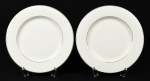 ROYAL BONE CHINA - Par de pratos rasos em porcelana Bone China esmaltada e vitrificada na cor branca, decorada com fio prateado nas bordas. Diâmetro: 27cm.