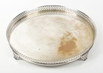 Bandeja circular em metal espessurado a prata, apoiada sobre 3 pés, laterais gradeadas. apresenta desgaste no banho. Altura e diâmetro: 6 x 41,5cm.