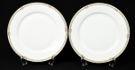 HC - Par de pratos rasos em porcelana esmaltada e vitrificada na cor branca, manufatura Thecoslovaca, bordas com decoração floral e fio dourado. Diâmetro: 24,5cm.