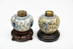 Par de antigos pequenos vasos em porcelana chinesa período Ming, atribuido a rituais de libação budista, sobre bases em madeira. Apresentam restauro nas bordas. Altura: 5,5cm.
